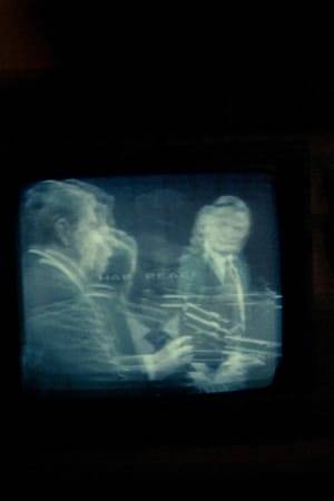 Kurt Kren recorded the last television debate in the Reagan/Mondale election campaign. In the viewfinder, the television filled the entire picture, but the viewfinder did not match the lens entirely so that the television screen in the picture was very little. That was not the plan, but Kren decided to "adopt" the film in the end.